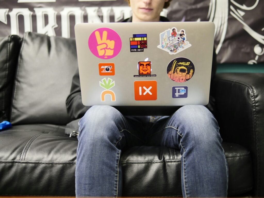 Student sitting on a couch with laptop on laps