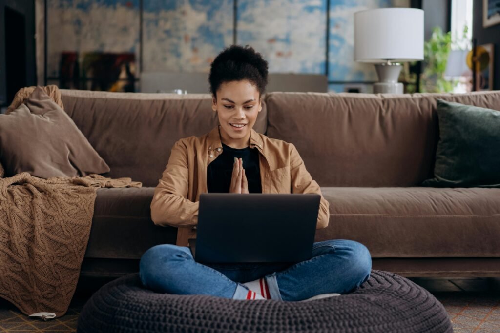 Woman sitting cross-legged on a chair and a laptop on her legs